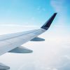 Airplane wing over blue sky travel