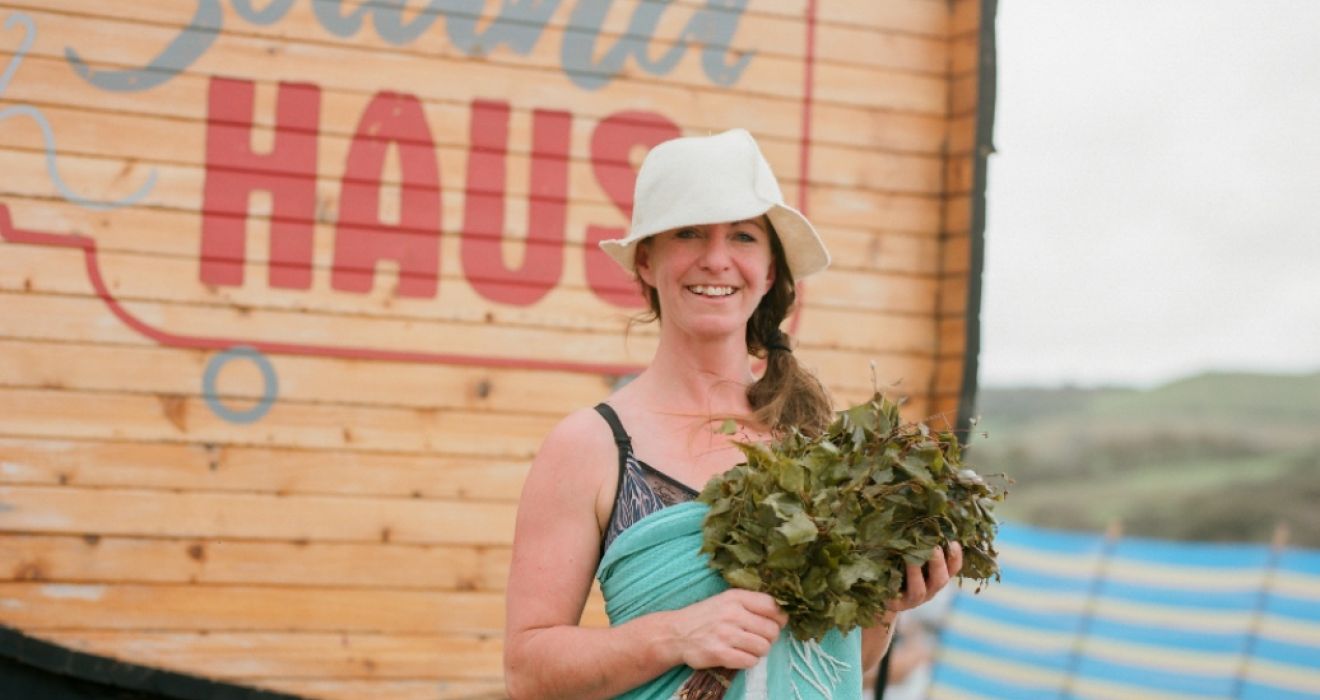 A woman stood next to an outdoor beach sauna