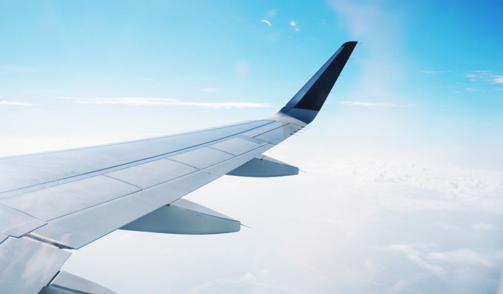 Airplane wing over blue sky travel