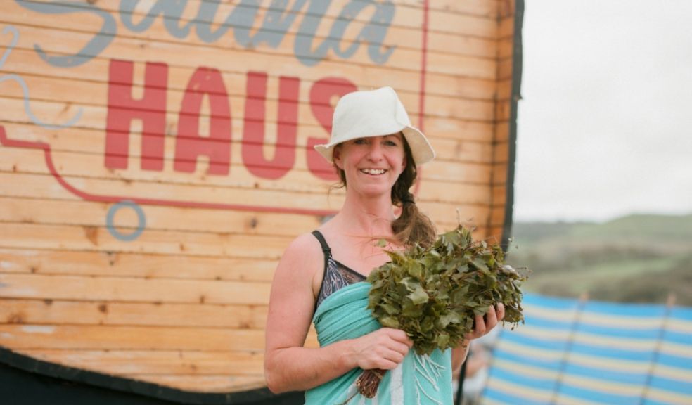 A woman stood next to an outdoor beach sauna