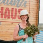 A woman stood next to an outdoor beach sauna