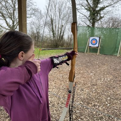 A young girl prepares to shoot an arrow at The Mole Resort